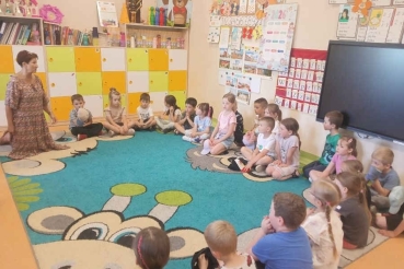 Dzieci siedzą na dywanie